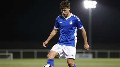A photorealistic image of an anonymous 21-year-old Rodez midfielder in a blue and white jersey with a white kit, playing...