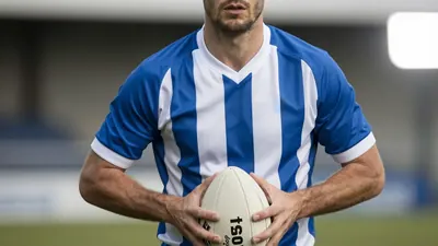 A photorealistic image of an anonymous Rodez player, aged 25-30, with a rugged build, wearing a blue and white striped...