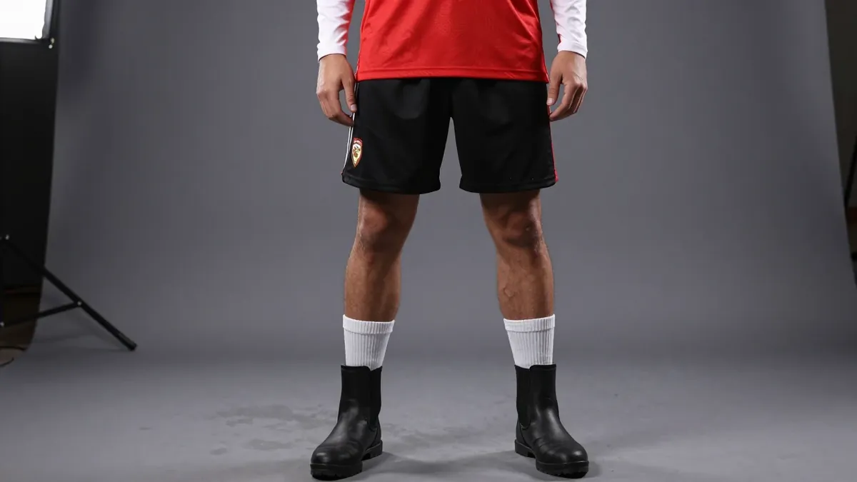 A photorealistic image of an anonymous Rodez player in a red jersey with white sleeves, a white collar and a red stripe...