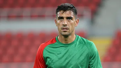 Mid-40s male coach, athletic build, waist-up, intense expression, eyes sharp, short dark hair, slight stubble, wearing a...